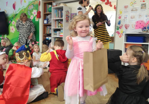 Dziewczynka niesie torbę z upominkiem za udział w konkursie.