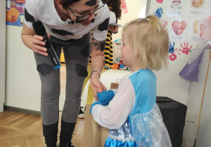 Dziewczynka odbiera podziękowanie za udział w konkursie.