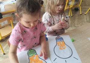 Dzieci naklejają żółte kartoniki do obrazka.