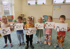 Dzieci prezentują wykonaną pracę z pingwinkami.