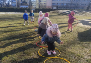 Dzieci skaczą do hula-hop.