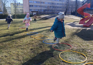 Dzieci skaczą do hula-hop.