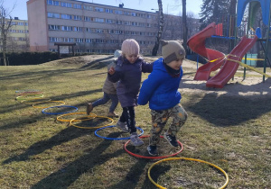 Dzieci skaczą do hula-hop.