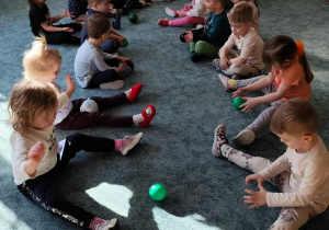 Dzieci turlają do siebie piłki