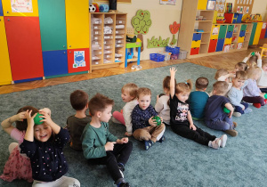 Dzieci podają sobie piłki nad głową