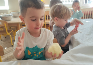 Dzieci ćwiczą rączki w zabawie sensorycznej.