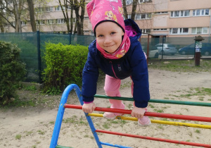 Dziewczynka bawi się na drabinkach.