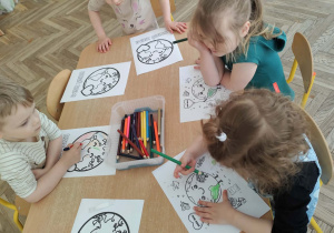 Dzieci kolorują obrazek ziemi.