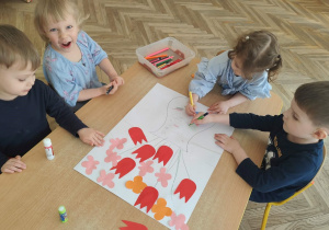 Dzieci wykonują w zespole pracę plastyczną.