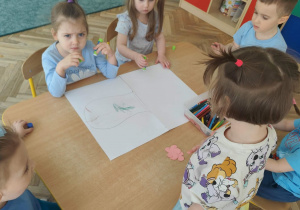 Dzieci wykonują w zespole pracę plastyczną.