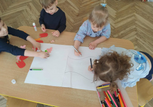 Dzieci wykonują w zespole pracę plastyczną.