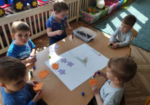 Dzieci wykonują w zespole pracę plastyczną.