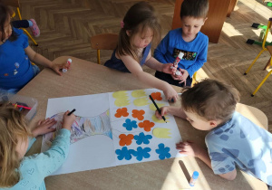 Dzieci wykonują w zespole pracę plastyczną.