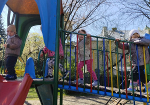 Dzieci bawią się na sprzęcie ogrodowym.