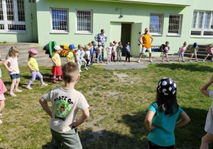 Dzieci naśladują ruchy taneczne za prowadzącym.
