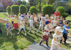 Dzieci naśladują ruchy taneczne za prowadzącym.