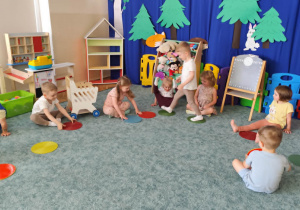 Dzieci biorą udział w zabawie z kolorowymi kołami.