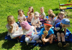 Dzieci spożywają wspólnie przekąskę.