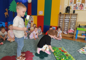 Dzieci ukrywają przysmaki dla psa w macie węchowej.