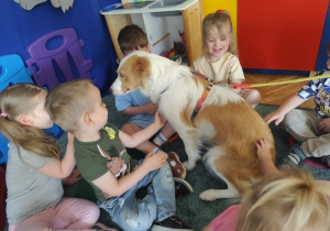 Dzieci uczą się delikatnego głaskania psa.