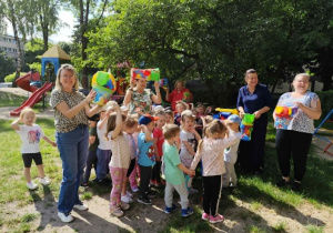 Dzieci otrzymują w prezencie od Pani Dyrektor nowe zabawki do piaskownicy.