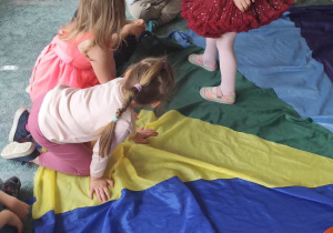 Dziewczynka częstuje dzieci cukierkami.