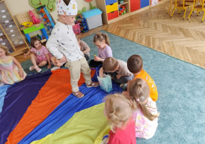 Chłopiec częstuje dzieci lizakami.