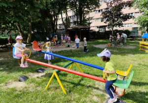 Dzieci korzystają ze sprzętu ogrodowego.